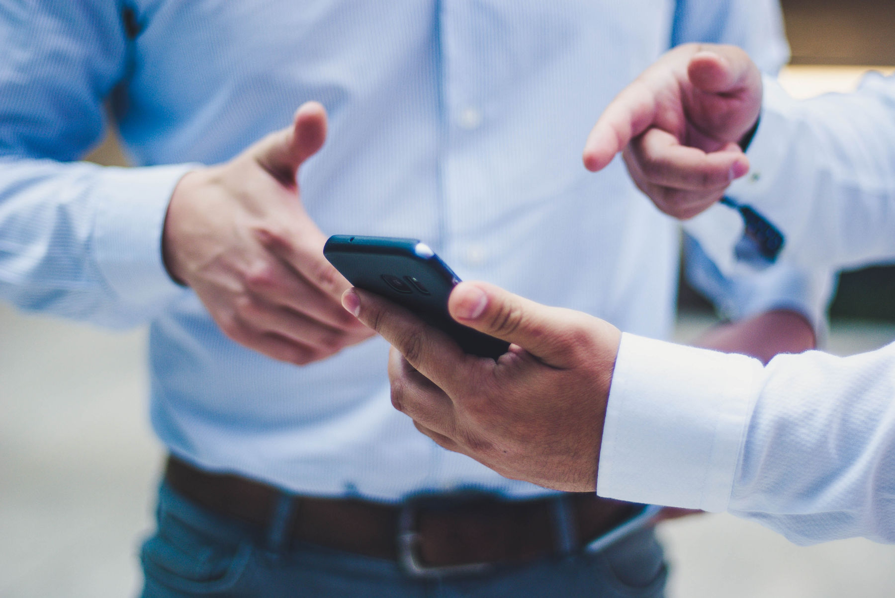 Two colleagues discussing figures on a phone